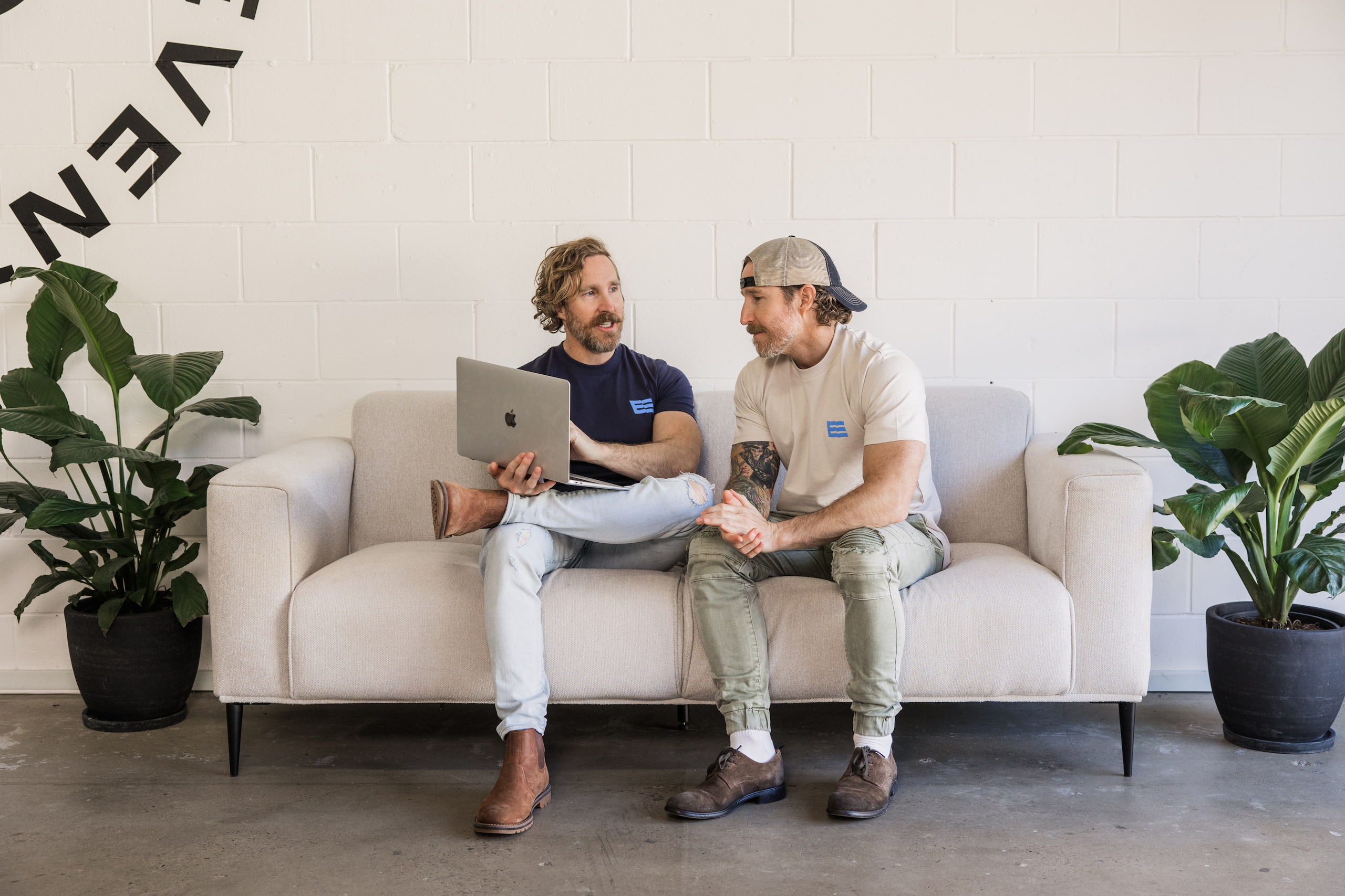 Two Embark team members collaborating on a couch